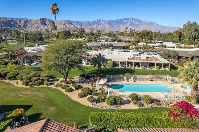 view of pool with a mountain view and a lawn