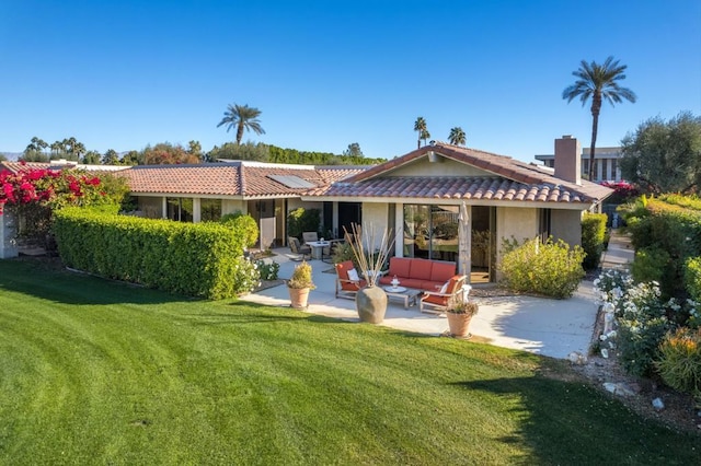 rear view of property with a yard, an outdoor living space, and a patio