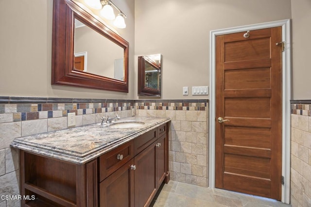 bathroom with vanity and tile walls