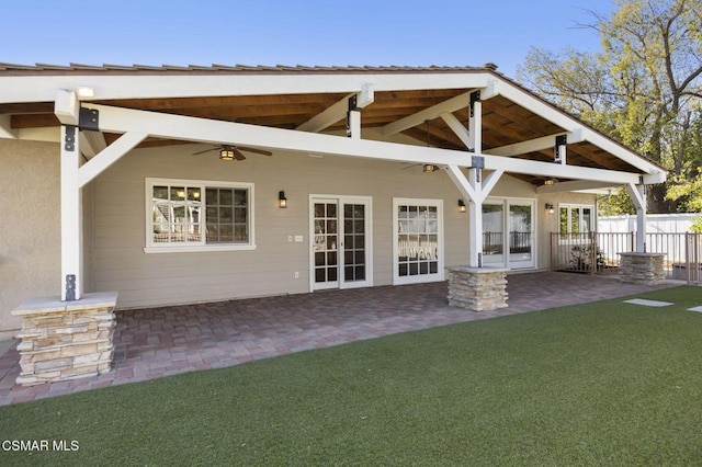 rear view of property with ceiling fan, french doors, a lawn, and a patio area