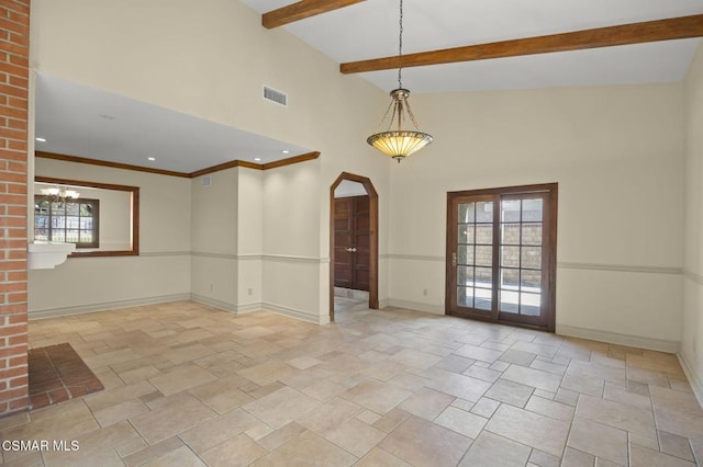 empty room with a chandelier and vaulted ceiling with beams