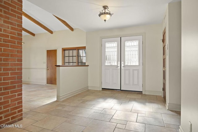 entrance foyer featuring beam ceiling and french doors