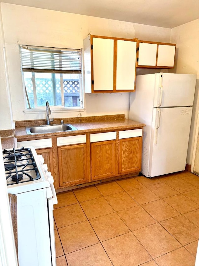 kitchen with light tile patterned floors, sink, and white appliances