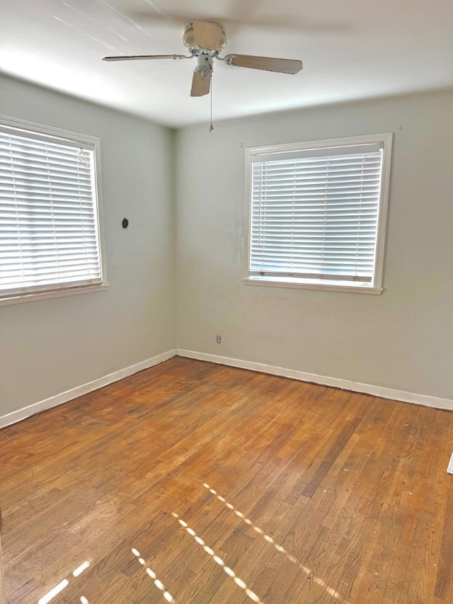 unfurnished room featuring ceiling fan, plenty of natural light, and wood-type flooring