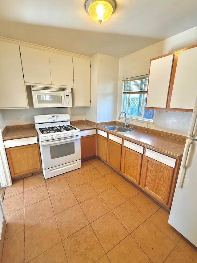 kitchen with sink, white appliances, and light tile patterned flooring