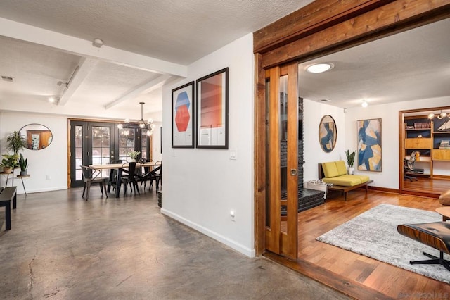 hall featuring french doors, a notable chandelier, beamed ceiling, and a textured ceiling