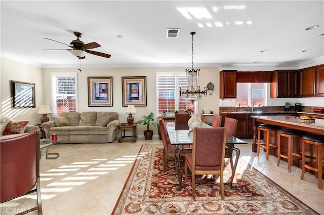 dining room featuring crown molding, ceiling fan with notable chandelier, sink, and light tile patterned floors