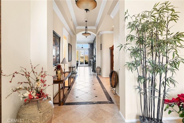 hallway featuring a raised ceiling, crown molding, and light tile patterned floors