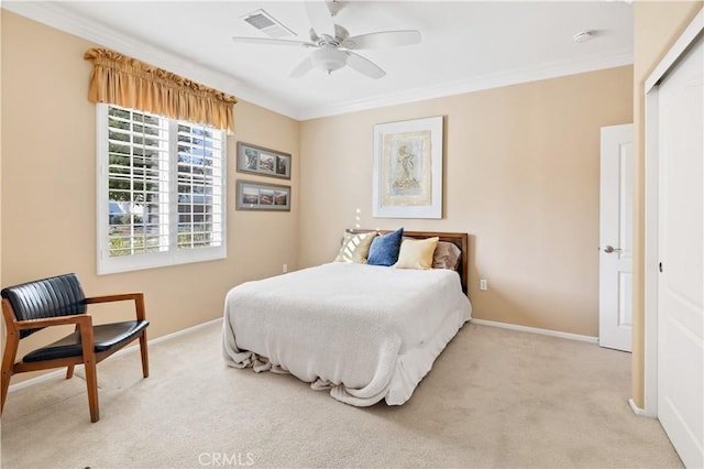 bedroom featuring crown molding, light carpet, ceiling fan, and a closet