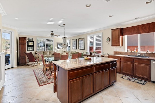 kitchen with pendant lighting, ornamental molding, sink, and a kitchen island