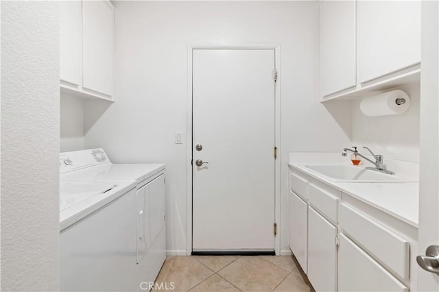 laundry room with light tile patterned flooring, cabinets, washer and clothes dryer, and sink