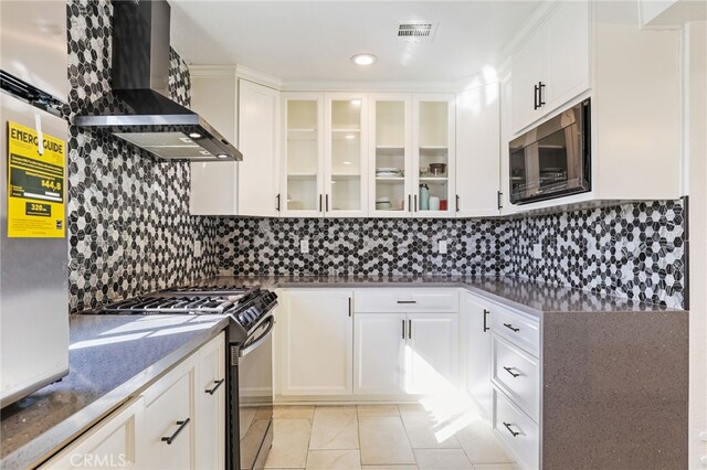 kitchen featuring range with gas cooktop, wall chimney range hood, tasteful backsplash, and white cabinetry