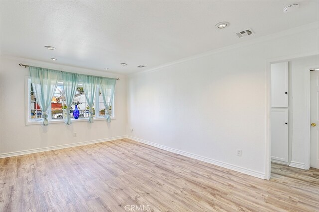 empty room featuring ornamental molding and light hardwood / wood-style floors