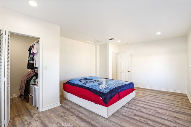 bedroom with wood-type flooring and a closet