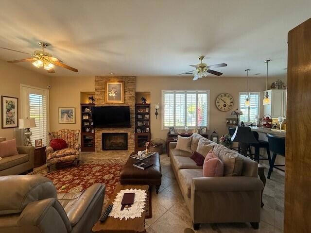 living room featuring ceiling fan and a fireplace