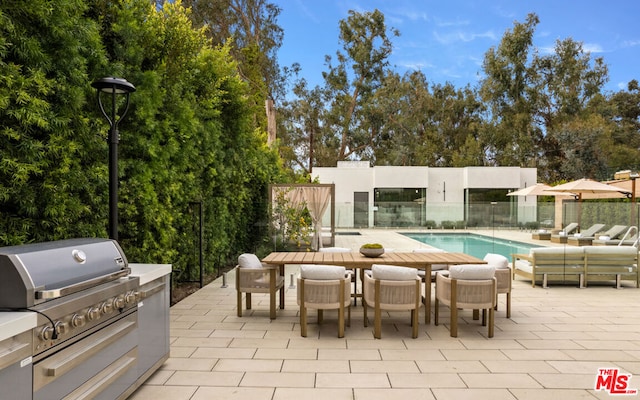 view of patio with a fenced in pool and a grill