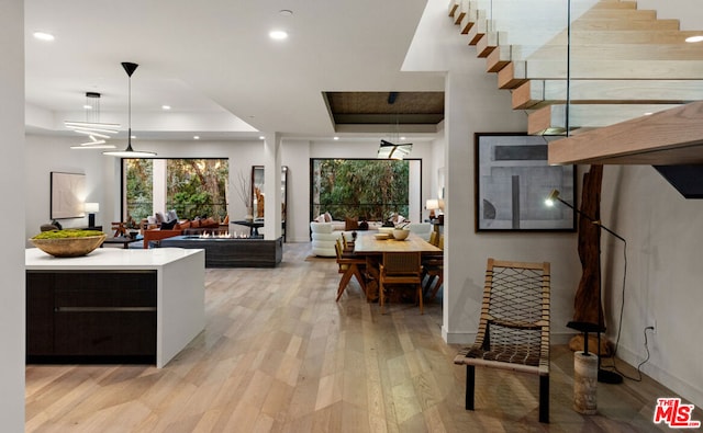 kitchen featuring pendant lighting, a tray ceiling, and light hardwood / wood-style flooring