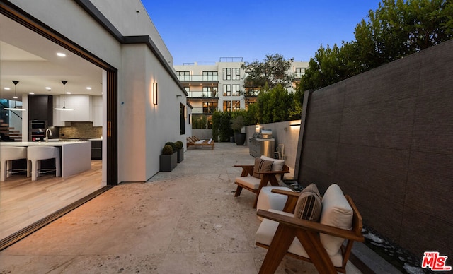 patio terrace at dusk featuring sink