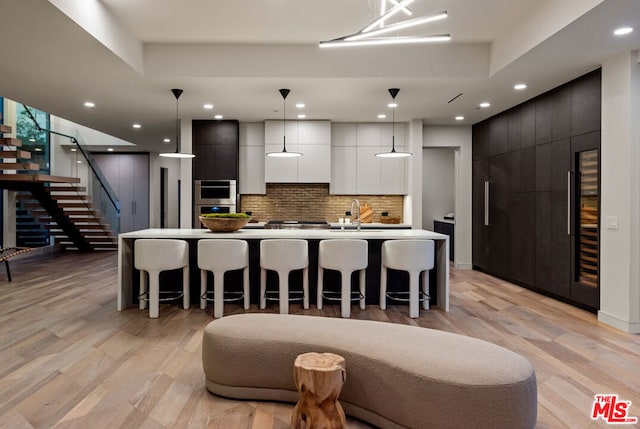 kitchen with decorative light fixtures, a breakfast bar area, and a spacious island