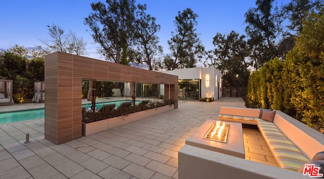 patio terrace at dusk featuring an outdoor fire pit