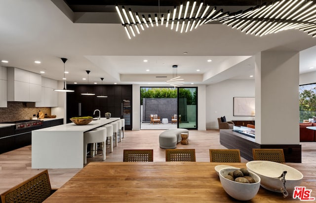 dining space featuring a raised ceiling, sink, and beverage cooler