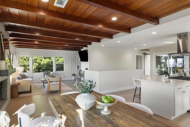 dining area featuring wood ceiling, beam ceiling, and a barn door