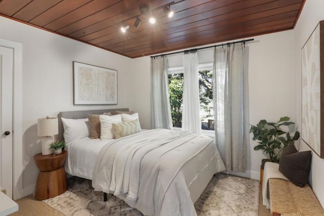 bedroom featuring light hardwood / wood-style flooring and wooden ceiling