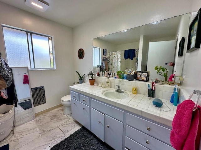 bathroom featuring vanity, heating unit, and toilet