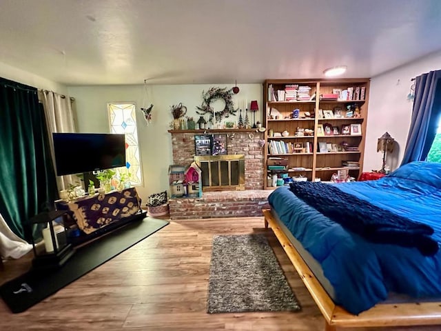 bedroom featuring hardwood / wood-style floors and a fireplace