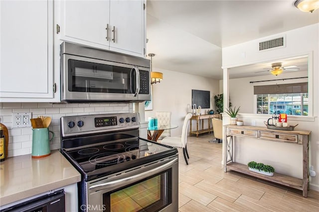 kitchen featuring white cabinetry, ceiling fan, appliances with stainless steel finishes, backsplash, and pendant lighting