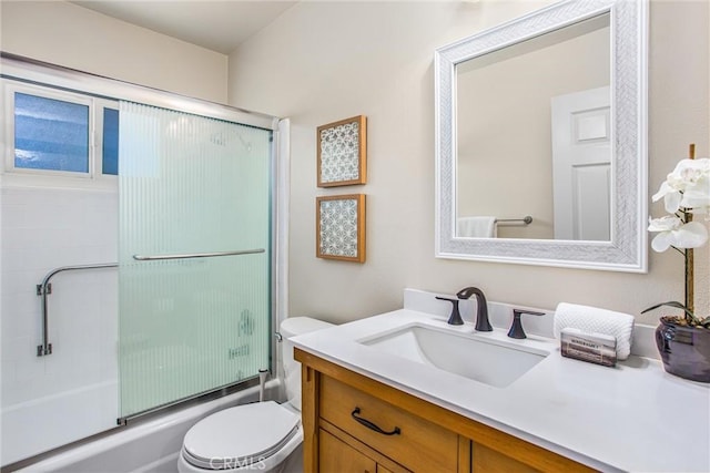 full bathroom featuring enclosed tub / shower combo, vanity, and toilet