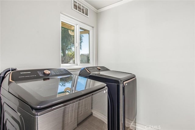 clothes washing area featuring ornamental molding and independent washer and dryer