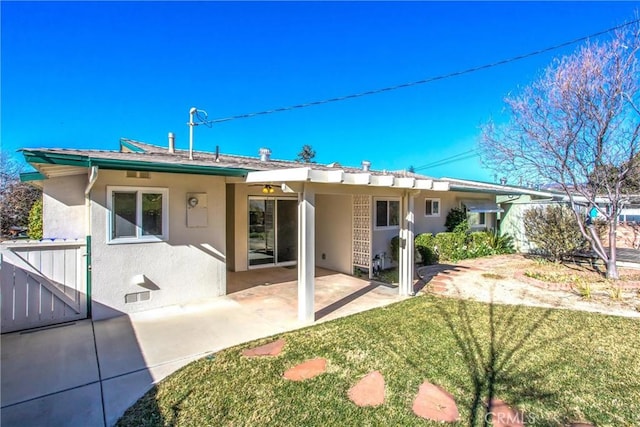 rear view of house with a yard and a patio