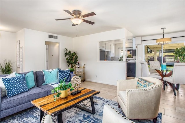 living room featuring ceiling fan with notable chandelier