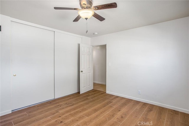 unfurnished bedroom featuring ceiling fan, hardwood / wood-style floors, and a closet