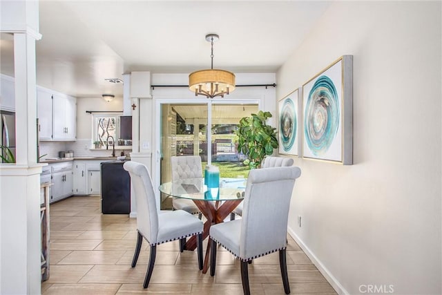 dining space with an inviting chandelier and sink