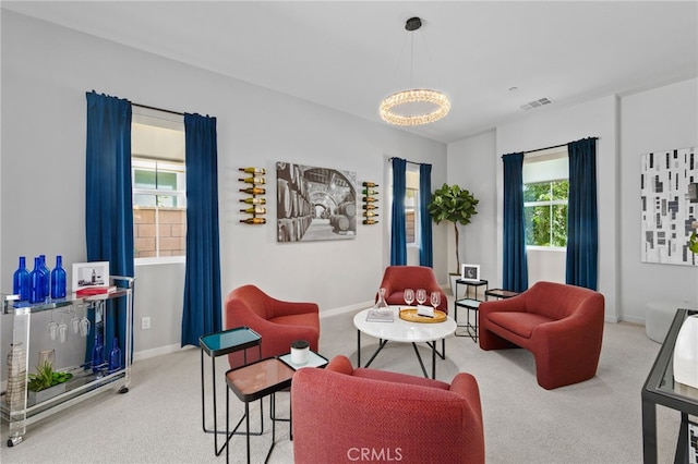 carpeted living room featuring a notable chandelier