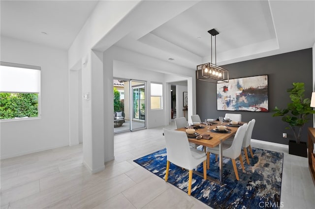 tiled dining area with a raised ceiling