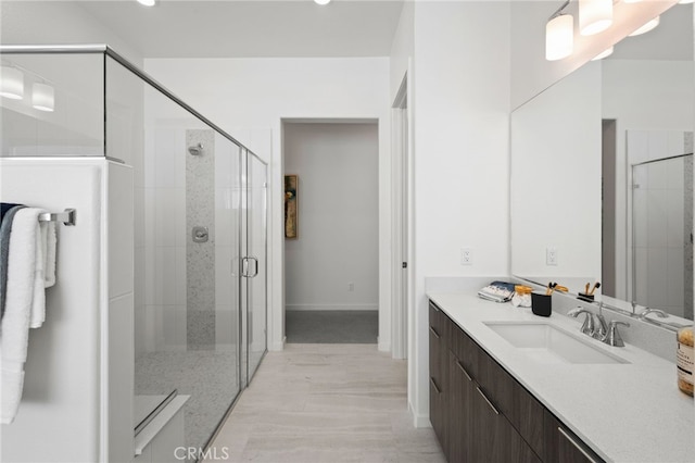 bathroom with vanity, wood-type flooring, and a shower with door