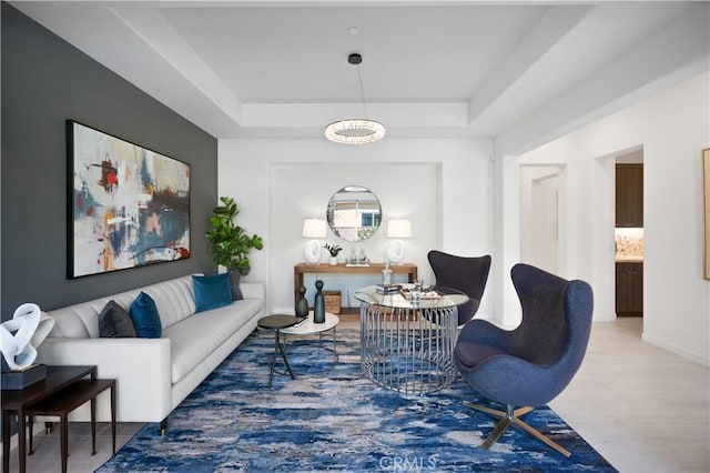 living area with a chandelier and a tray ceiling