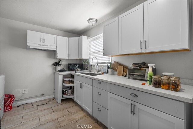 kitchen featuring sink and white cabinetry