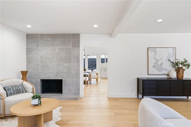 interior space featuring a fireplace, light hardwood / wood-style floors, and beam ceiling