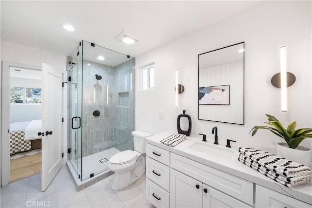 bathroom featuring toilet, a wealth of natural light, an enclosed shower, and vanity