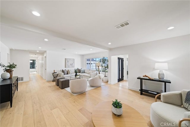 living room featuring light hardwood / wood-style floors and beamed ceiling