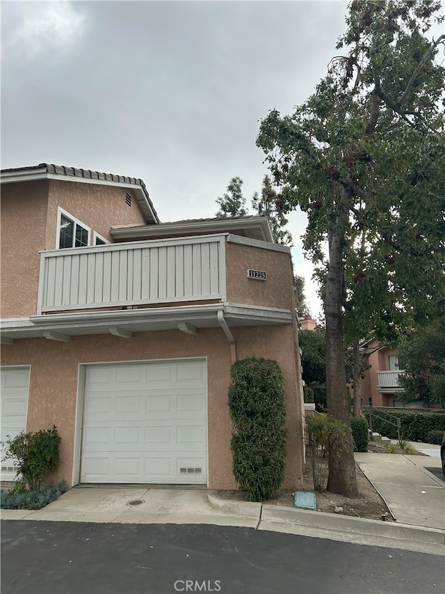 view of front facade featuring a balcony and a garage