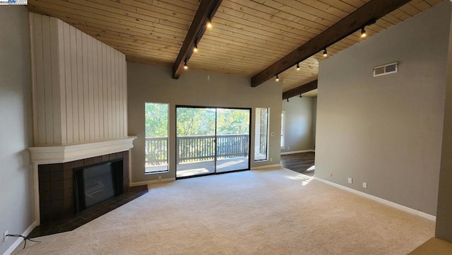 unfurnished living room featuring wood ceiling, dark carpet, high vaulted ceiling, a tile fireplace, and beamed ceiling