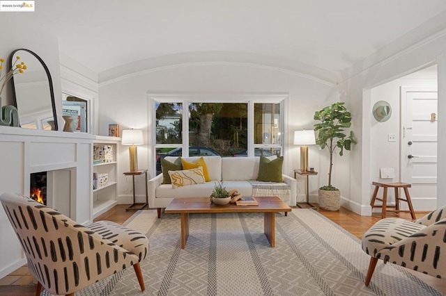 sitting room with wood-type flooring and vaulted ceiling