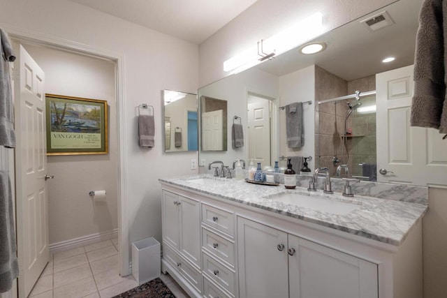 bathroom featuring a tile shower, tile patterned floors, and vanity