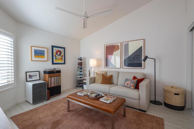 living room featuring ceiling fan, light hardwood / wood-style floors, and vaulted ceiling