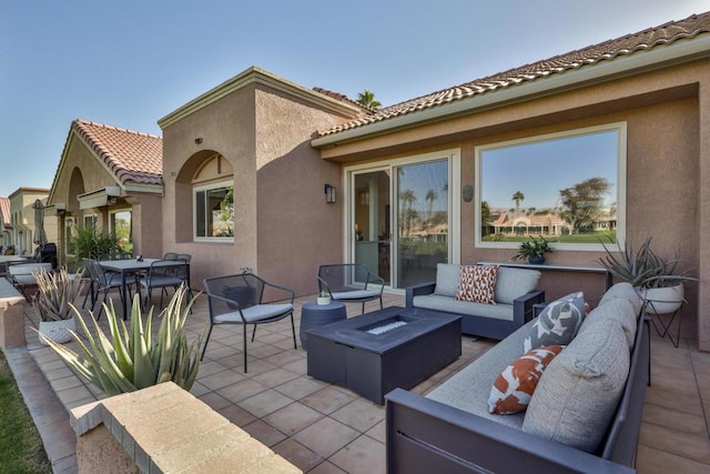 view of patio with an outdoor living space with a fire pit